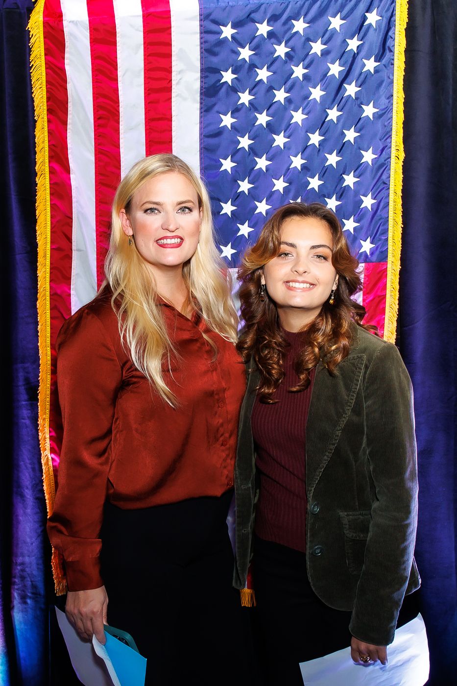 Tarin and Penny standing together in front of an American flag after the town hall.